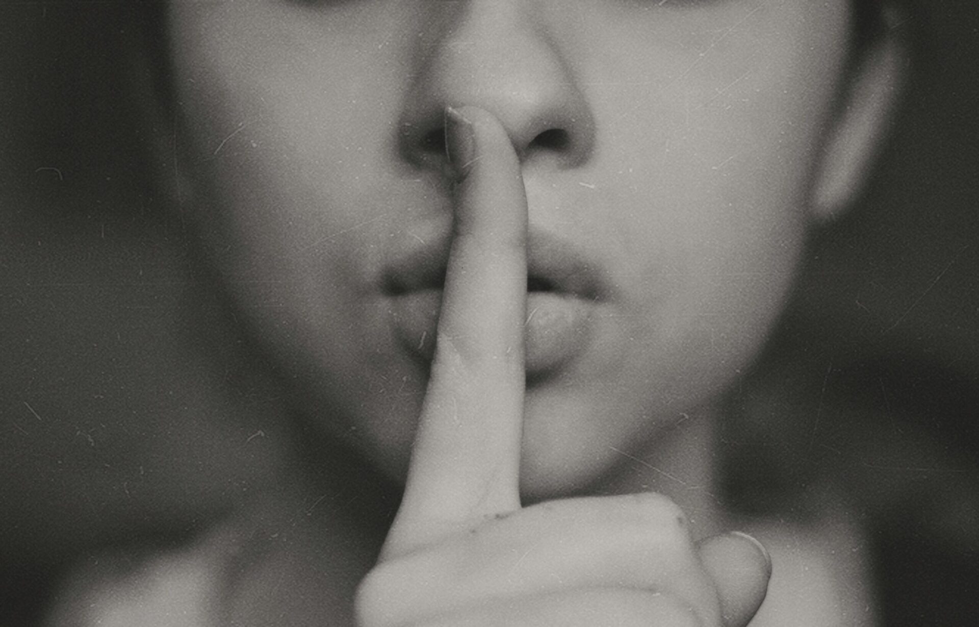 Girl with finger to mouth denoting silence
